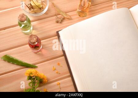 Livre de recettes vierge pour la préparation de la médecine des plantes naturelles sur table en bois avec les plantes médicinales et aromatiques. Vue d'en haut. Compositi horizontale Banque D'Images