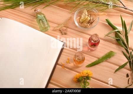 Livre de recettes vierge pour la préparation de la médecine des plantes naturelles sur table en bois avec les plantes médicinales et aromatiques. Vue d'en haut. Compositi horizontale Banque D'Images