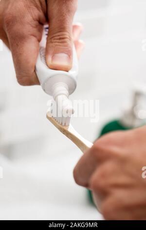 Libre d'un homme de race blanche à l'aide d'une brosse à dents dans la salle de bain en bambou Banque D'Images