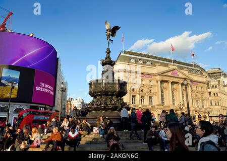 Royaume-uni, Londres, Piccadilly Circus, foule assis au pied de la statue d'Eros Banque D'Images