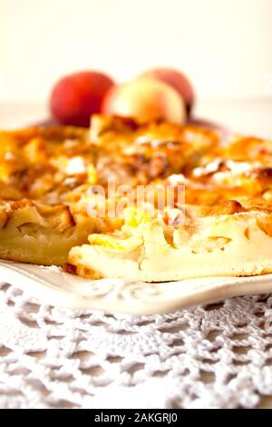 Abricot Pomme fruits maison peach pie closeup on white en serviette sur fond blanc table rustique avec une tasse de thé. Focus sélectif. Copier l'espace. Banque D'Images