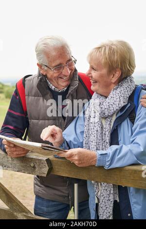 Couple de retraités sur la marche de vacances reposant sur la porte avec la carte Banque D'Images