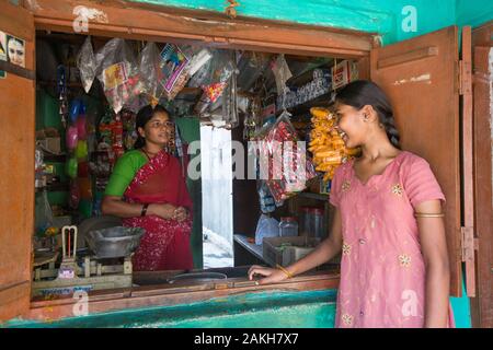 Description : à l'aide d'un prêt de son groupe d'entraide (SHG), Shivamma a mis en place une petite boutique pour aider à couvrir les coûts associés à sa fille Sara Banque D'Images