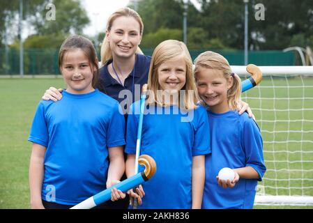 Portrait De L'Équipe De Hockey Des Filles Avec Entraîneur Des Femmes À L'École Banque D'Images