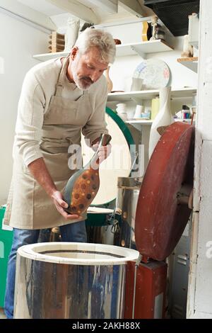 Homme Mûr Dans Pottery Studio Firing Vase À Kiln Banque D'Images