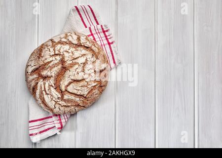Miche de pain de seigle sur un fond de bois blanc. Banque D'Images