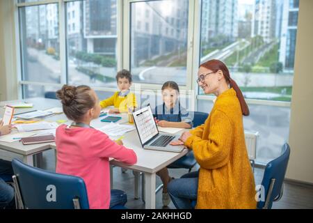 Enseignant travaillant avec un petit groupe d'enfants Banque D'Images