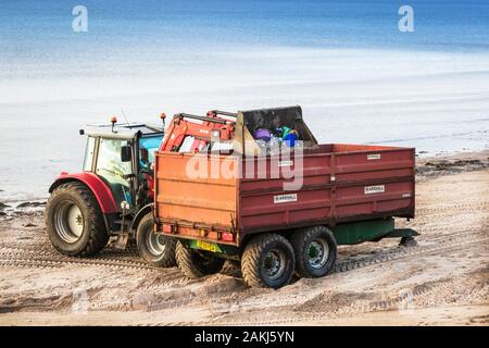 Tracteur et remorque étant utilisés pour nettoyer la pollution et déchets de la plage publique, Irvine, Ayrshire du Nord, Royaume-Uni Banque D'Images