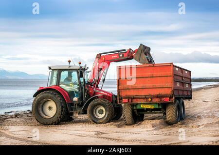 Tracteur et remorque étant utilisés pour nettoyer la pollution et déchets de la plage publique, Irvine, Ayrshire du Nord, Royaume-Uni Banque D'Images