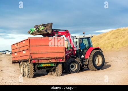 Tracteur et remorque étant utilisés pour nettoyer la pollution et déchets de la plage publique, Irvine, Ayrshire du Nord, Royaume-Uni Banque D'Images