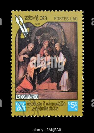 Timbre-poste annulé imprimé par le Laos, qui montre la peinture à des motifs religieux par Corregio, vers 1984. Banque D'Images