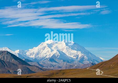 Route sinueuse menant à la montagne de Denali en Alaska avec ciel bleu et de nuages flottant au-dessus de la Montagne Banque D'Images