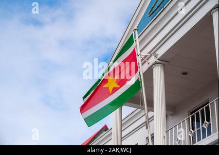 Drapeau national du Suriname volant à l'extérieur d'un bâtiment sur Canal Street dans la capitale Paramaribo dans ce petit pays sud-américain Banque D'Images