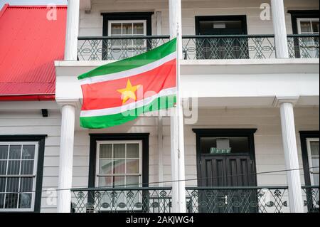 Drapeau national du Suriname volant à l'extérieur d'un bâtiment sur Canal Street dans la capitale Paramaribo dans ce petit pays sud-américain Banque D'Images