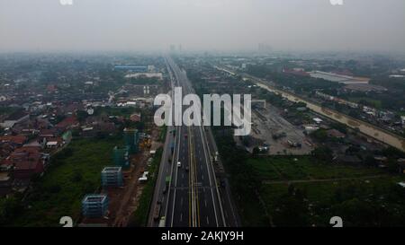 BEKASI, WESTJAVA, INDONÉSIE : 10 janvier 2020 : drone aérien vue de l'autoroute multilevel junction road avec des voitures en mouvement après la saison des pluies. Les voitures sont floues Banque D'Images