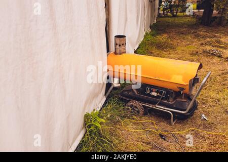 L'élément de chauffage de la chaudière a été chauffé au rouge dans une pièce sombre. Le pistolet à air chaud est connecté au réseau électrique et chauffe l'air dans le Banque D'Images