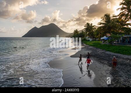 Le Diamant, Martinique, France - 16 août 2019 : Le Diamant Beach en Martinique, avec les hommes de jouer avec une balle et femme endormie dans la montagne backgroun Banque D'Images