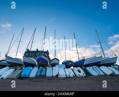 Bateaux à voile hors de l'eau pour l'hiver avec des bateaux à rames, Fisherrow Harbour, Musselburgh, Écosse, Royaume-Uni Banque D'Images