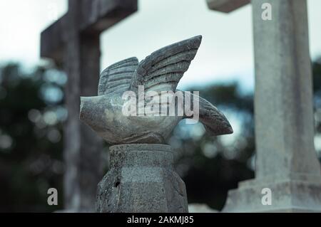 Une tombe en pierre sans tête au cimetière catholique. Dove symbolisant l'Esprit Saint. Banque D'Images