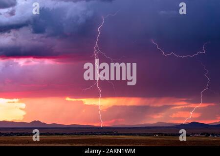 Coup de foudre à la suite d'un orage de mousson alors que des nuages d'orage spectaculaires prennent des couleurs de coucher de soleil sur Prescott Valley, Arizona, États-Unis Banque D'Images