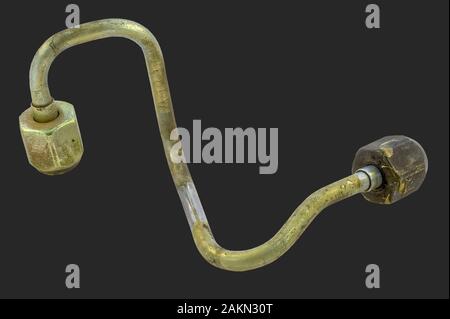 Une ligne de l'injecteur de carburant en acier pour un moteur diesel isolé sur fond sombre qui a dû être remplacé en raison d'un défaut. Banque D'Images