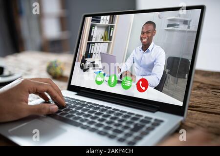 Portrait Of Businessman Using Laptop At Desk In Office Banque D'Images