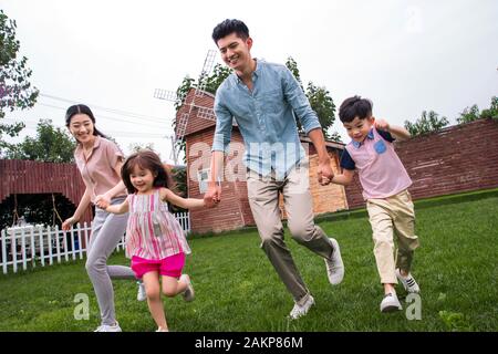 Happy family run sur l'herbe Banque D'Images