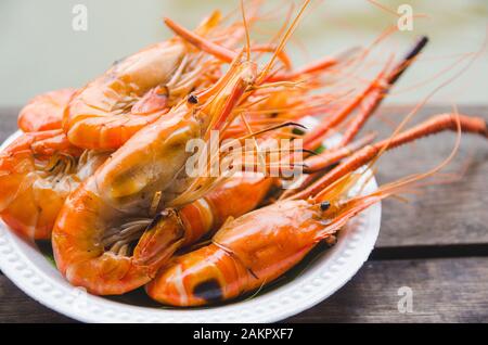 crevettes grillées sur une plaque blanche sur une table en bois Banque D'Images
