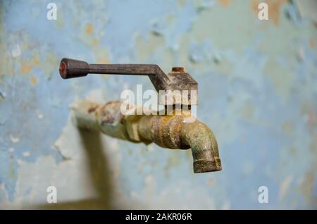 robinet d'eau rouillé sur un mur pâle Banque D'Images