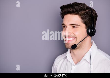 Gros plan photo de l'employé du centre d'appels qui a réussi à porter un casque écoute aider les clients avec des problèmes isolés sur fond gris Banque D'Images