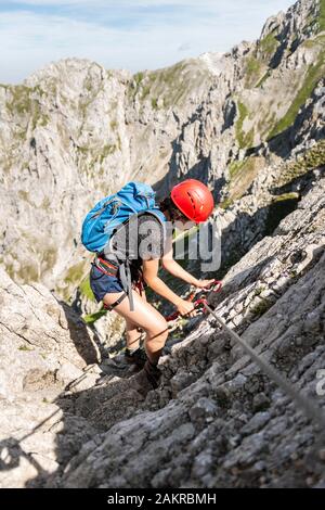 Mountaineer avec casque sur un route de corde fixe, Mittenwald via ferrata, Karwendel, Mittenwald, Allemagne Banque D'Images