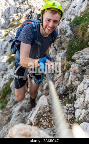 Mountaineer, jeune homme avec un casque sur la route de corde fixe, Mittenwald via ferrata, Karwendel, Mittenwald, Allemagne Banque D'Images