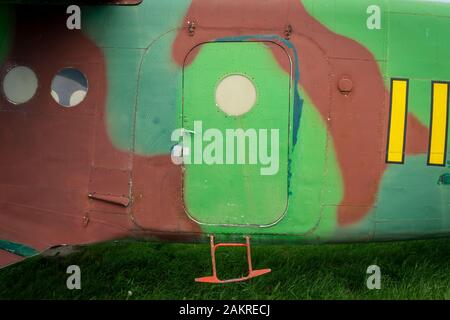 Camouflage coloré couleurs sur un fuselage d'avion un vieux millésime avec porte et petite marche garé dans un champ d'herbe Banque D'Images