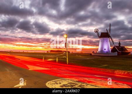 Lytham, Lancashire. UK Weather.10 Janvier, 2020.couleurs sourdes à dawnm et Lumières floues de la circulation leavig sentiers rouges, après une nuit froide sur la côte de Fylde. Lytham Windmill comme levers sur Lytham vert dans la ville côtière de Lytham St Annes, Lancashire, Angleterre. Il est du type connu sous le nom de tower mill et a été conçu pour moudre le blé et d'avoine pour faire de la farine ou du son. /AlamyLiveNews MediaWorldImages crédit ; Banque D'Images