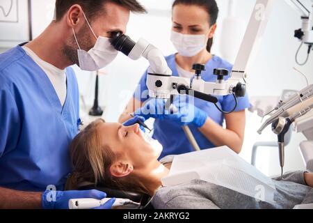 Male dentist travailler avec microscope Banque D'Images