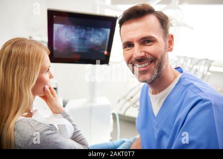 Portrait of smiling et confiant dans la clinique dentiste dentiste Banque D'Images