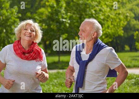 Deux smiling seniors jog ensemble dans la nature en été Banque D'Images