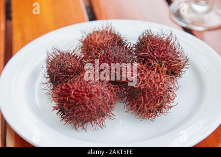 Une plaque de Rambutans, un fruit rouge spiky. Banque D'Images