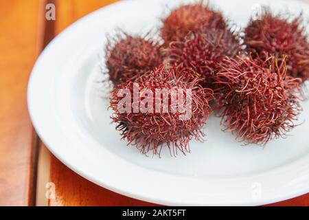 Une plaque de Rambutans, un fruit rouge spiky. Banque D'Images