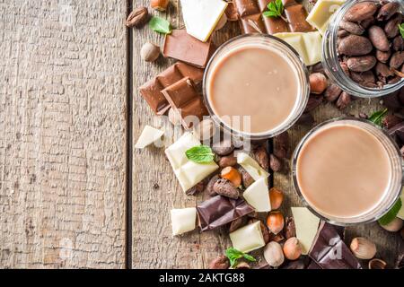 Boisson alcoolisée et forte. Liqueur de chocolat au lait et morceaux de chocolat noir. Espace de copie d'arrière-plan en bois Banque D'Images