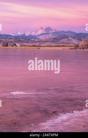 Les lacs commencent à se geler pendant l'hiver alors que le lever du soleil au-dessus de long Peak Mountain brille dans Pink dans le nord du Colorado Banque D'Images