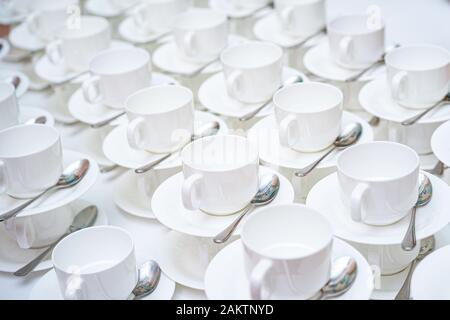 Beaucoup de tasses à café blanches. Vue de dessus sur de nombreuses tasses blanches propres vides empilées en rangées pour le thé ou le café. Banque D'Images