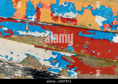 Abstraite de la côté d'un bateau de pêche en bois montrant de nombreuses couches de peinture altérée. Banque D'Images