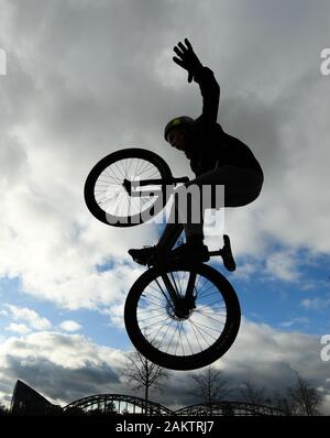 10 janvier 2020, Hessen, Frankfurt/Main : un adolescent saute avec son dirtjump vélo sur la zone du patineur dans le Osthafenpark en face d'un ciel nuageux. Photo : Arne Dedert/dpa Banque D'Images