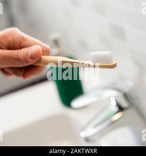 Libre d'un homme de race blanche à l'aide d'une brosse à dents dans la salle de bain en bambou Banque D'Images