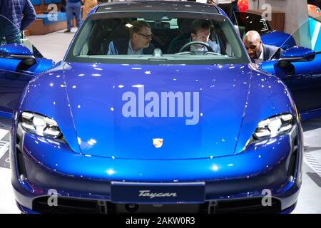 (200110) -- Bruxelles, 10 janvier 2020 (Xinhua) -- Les visiteurs d'essayer une Porsche Taycan voiture au 98e Salon de l'Automobile de Bruxelles à Bruxelles, Belgique, le 9 janvier 2020. Le 98e Salon de l'Automobile de Bruxelles est ouvert au public du 10 au 19 janvier. (Xinhua/Zhang Cheng) Banque D'Images