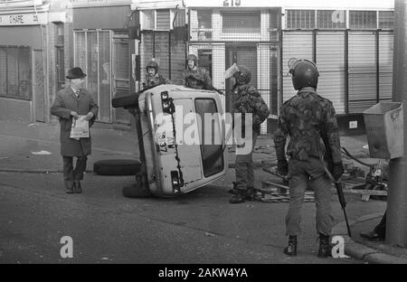 Les troupes en patrouille dans la région de Falls Road catholique de Belfast rencontrent un civil a renversé par une voiture qui forment une barricade pendant les émeutes dans les premières heures du matin. Des émeutes ont éclaté dans la ville peu après l'annonce de Bobby Sands, mort en prison labyrinthe. Banque D'Images