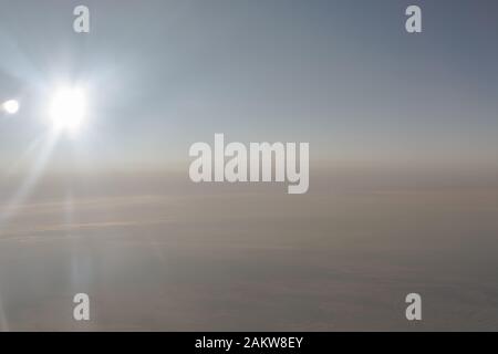 Dans l'air, vue de l'aile de l'avion avec l'horizon du ciel bleu foncé et nuages arrière-plan en heure de lever du soleil, vue de la fenêtre de l'avion Banque D'Images