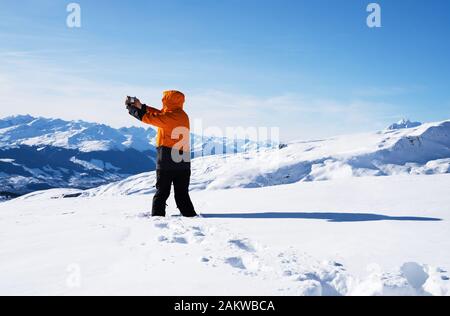 Homme avec photographie Téléphone sur Paysage enneigé Banque D'Images