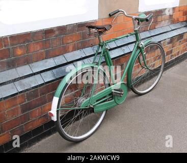 Un Vélo Rusty Vintage Penchant Contre Un Bâtiment De Brique. Banque D'Images